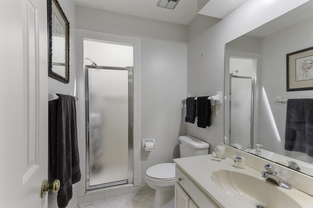 bathroom with a shower stall, toilet, and vanity