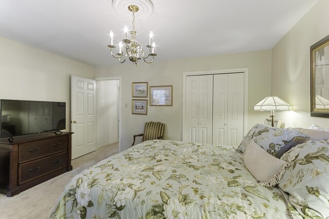 bedroom featuring carpet, a chandelier, and a closet