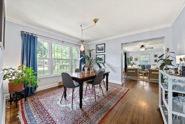 dining room with dark wood-style flooring, crown molding, a ceiling fan, and baseboards