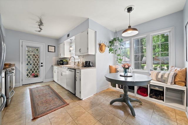 kitchen with stainless steel appliances, light countertops, healthy amount of natural light, and white cabinets
