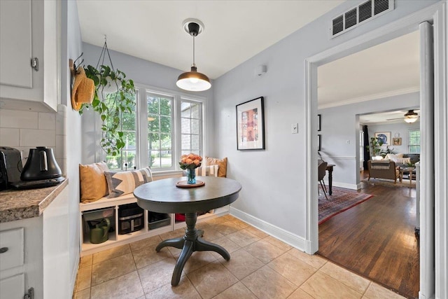 dining room with baseboards, crown molding, ceiling fan, and light tile patterned floors