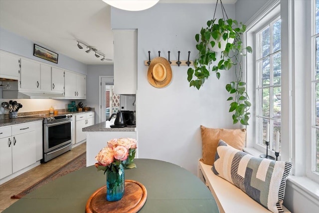 kitchen with electric stove, healthy amount of natural light, and white cabinets