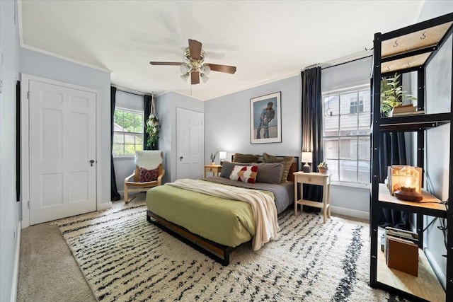 bedroom with baseboards, crown molding, carpet floors, and a ceiling fan