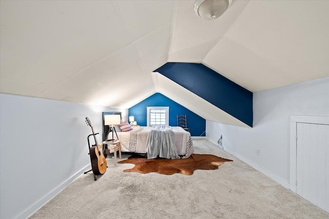 carpeted bedroom with lofted ceiling and baseboards