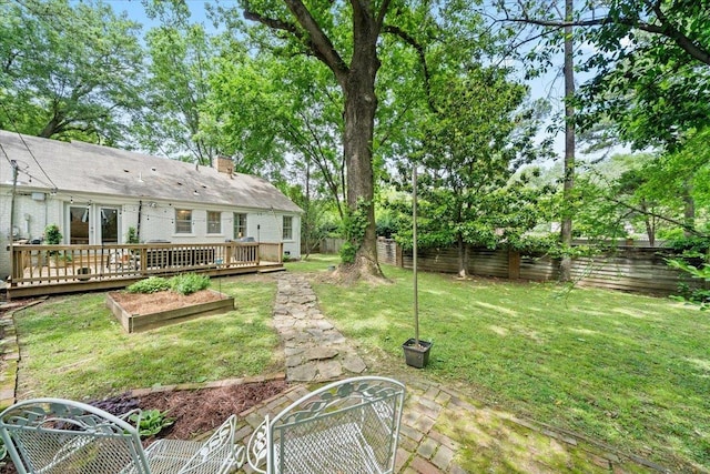 view of yard with a wooden deck and a garden
