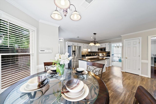 8606 Meadow Green Dr, Memphis, TN 38016 - dining space with dark wood-type flooring, a chandelier, and crown molding