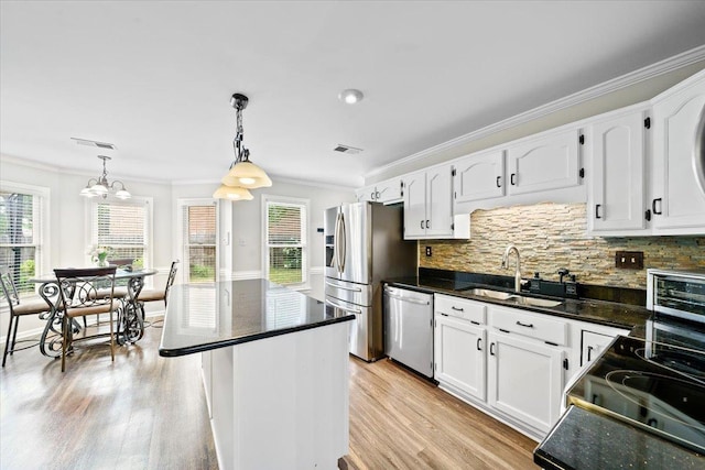 8606 Meadow Green Dr, Memphis, TN 38016 - kitchen with stainless steel appliances, a sink, ornamental molding, white cabinetry, and decorative backsplash