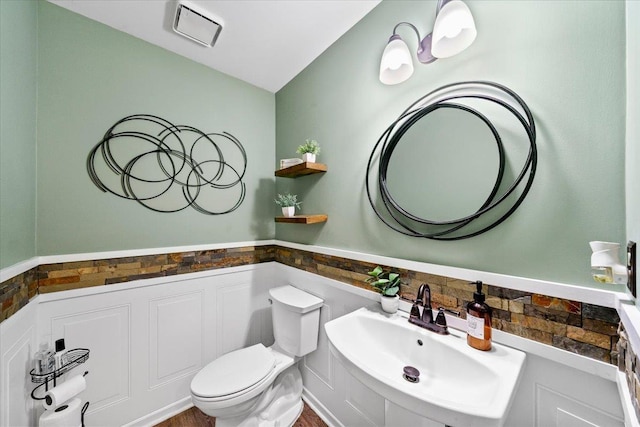 8606 Meadow Green Dr, Memphis, TN 38016 - bathroom with a sink, toilet, and a wainscoted wall
