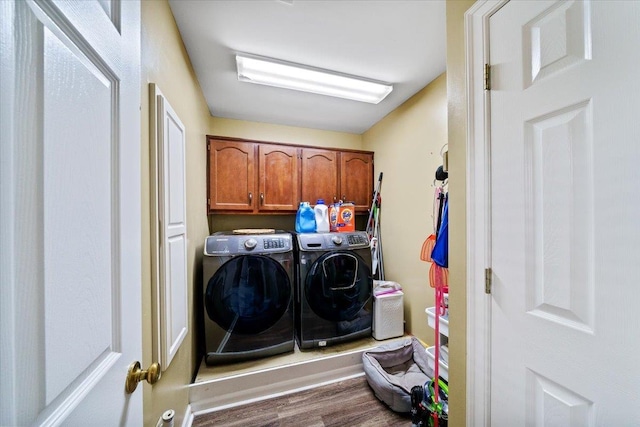 8606 Meadow Green Dr, Memphis, TN 38016 - clothes washing area with independent washer and dryer, wood finished floors, and cabinet space