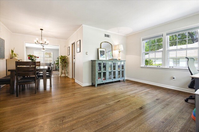 dining area with wood finished floors, baseboards, ornamental molding, and a chandelier