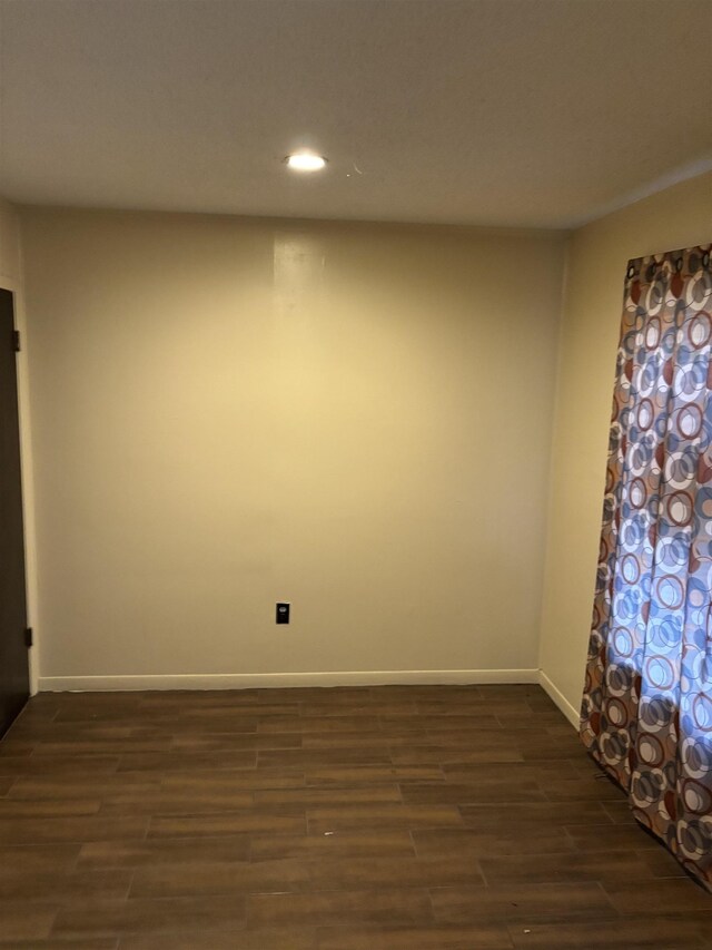 unfurnished room with dark wood finished floors, recessed lighting, and baseboards