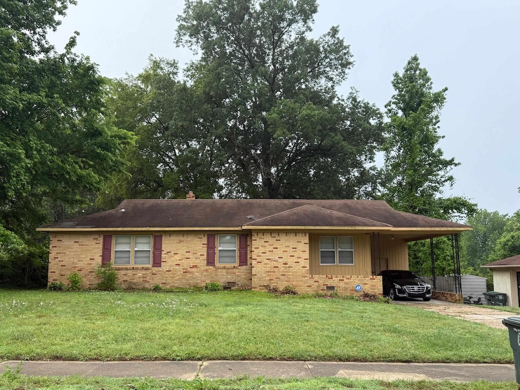 1975 Wellons Ave, Memphis, TN 38127 - view of front of house with brick siding, a carport, a front lawn, and concrete driveway