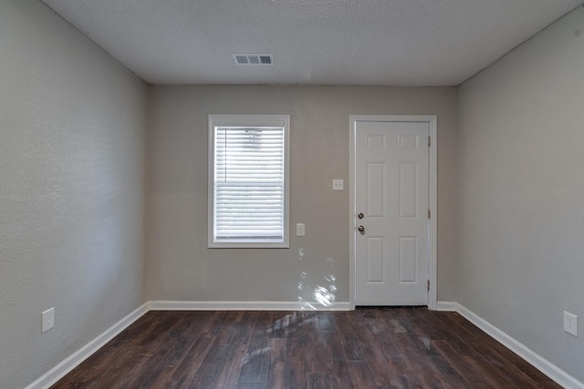 empty room with dark wood-style flooring and baseboards