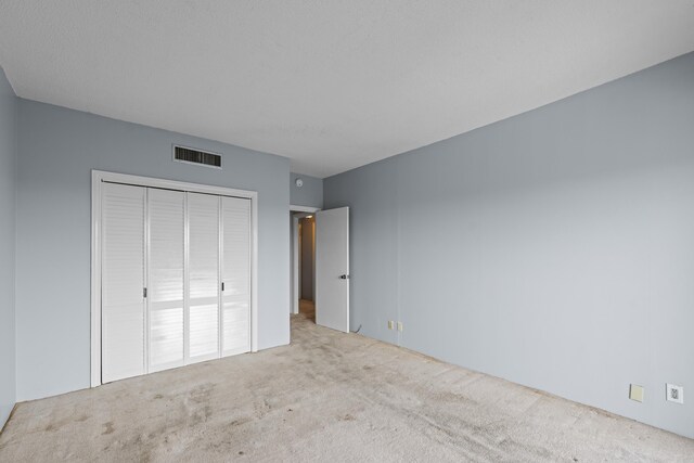 unfurnished bedroom featuring carpet and a closet