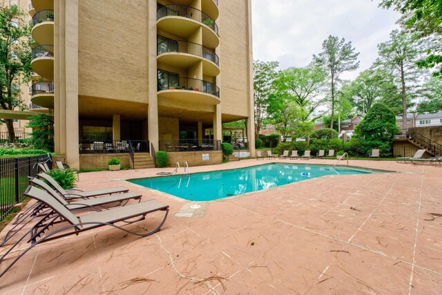 community pool featuring a patio area and fence