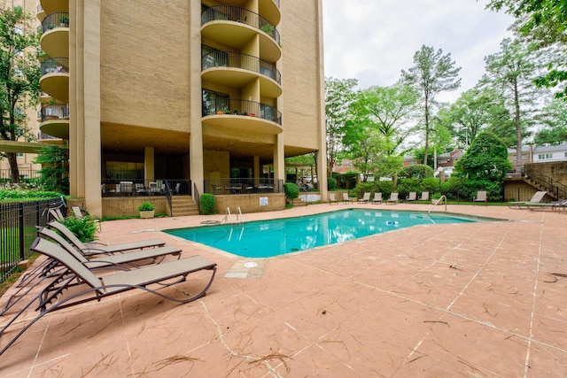 community pool featuring a patio and fence