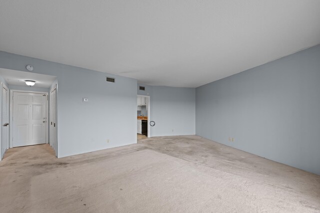 unfurnished living room featuring light carpet