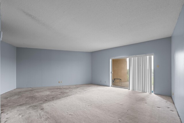 carpeted empty room with a textured ceiling