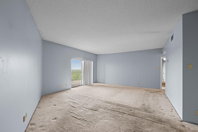 carpeted spare room featuring a textured ceiling