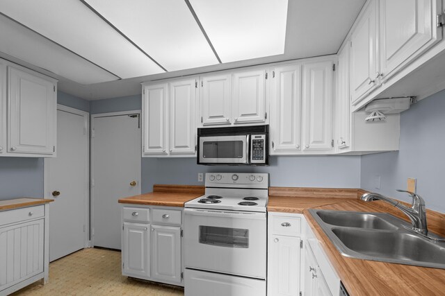 kitchen with stainless steel microwave, white electric range oven, a sink, and white cabinetry