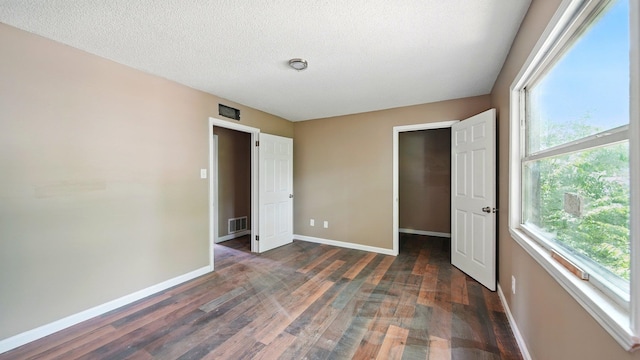 3554 Morning Dew Ct Unit 11, Memphis, TN 38118 - unfurnished bedroom with multiple windows, wood finished floors, baseboards, and a textured ceiling