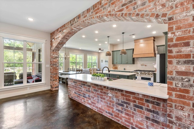 6978 Vaiden Rd, Hernando, MS 38632 - kitchen with range with two ovens, premium range hood, green cabinetry, a sink, and concrete floors