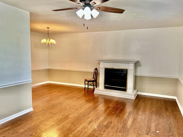 182 Hargett Dr, Ripley, TN 38063 - unfurnished living room featuring a fireplace with raised hearth, wood finished floors, a ceiling fan, and baseboards