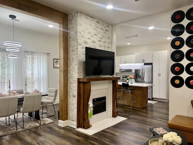 living area with dark wood finished floors, a fireplace, and recessed lighting