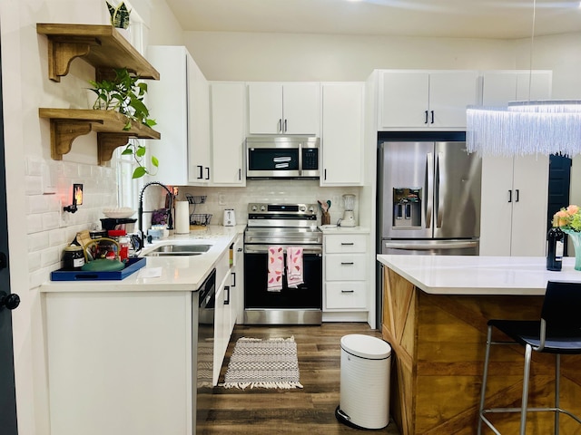 kitchen featuring stainless steel appliances, a sink, open shelves, dark wood finished floors, and light countertops