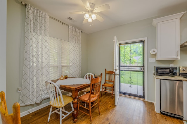 dining space with light wood-style flooring, ceiling fan, and baseboards