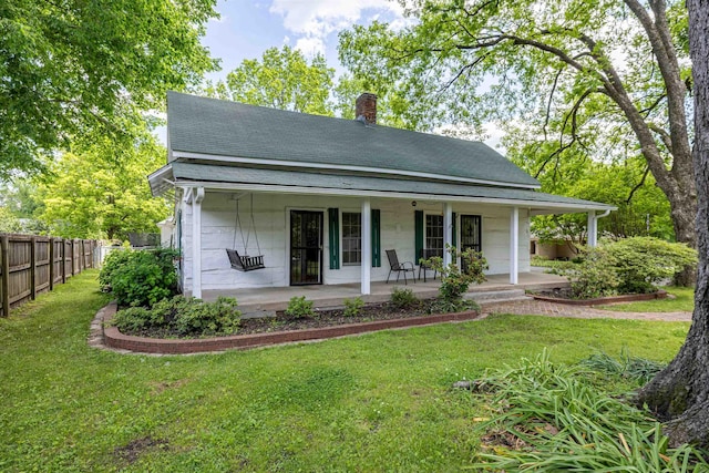 rear view of house featuring a chimney, a shingled roof, and covered porch