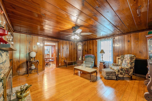living area with wooden ceiling, wood walls, wood finished floors, and a ceiling fan