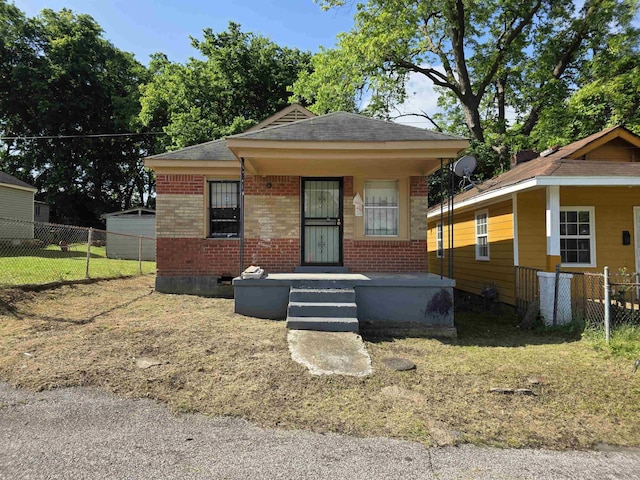 view of front of house with brick siding, fence, and roof with shingles