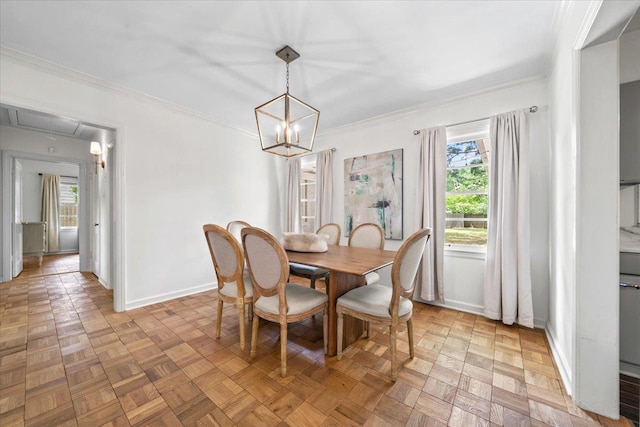 dining space featuring crown molding, baseboards, and a chandelier