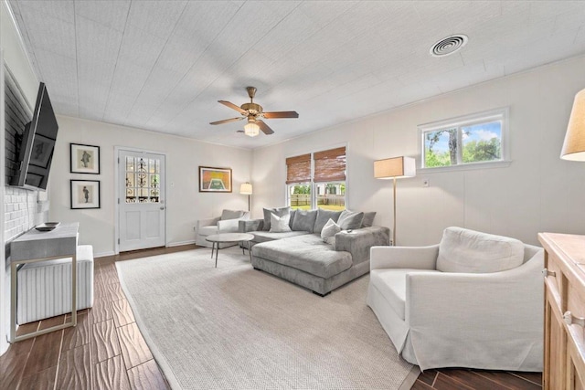 living area featuring healthy amount of natural light, a ceiling fan, and wood finished floors