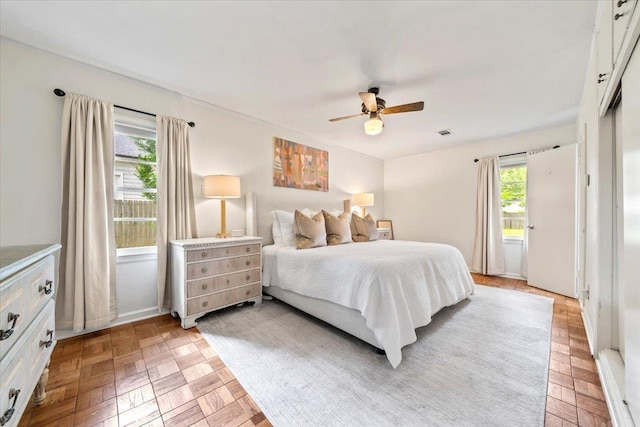 bedroom featuring multiple windows and a ceiling fan