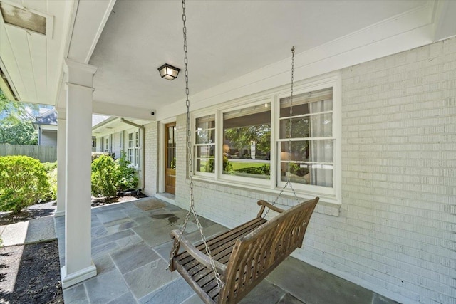 view of patio / terrace featuring a porch and fence