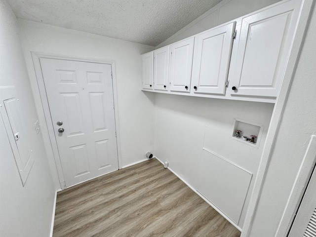 841 Simmons Rd, Munford, TN 38023 - clothes washing area with cabinet space, washer hookup, light wood-type flooring, a textured ceiling, and baseboards