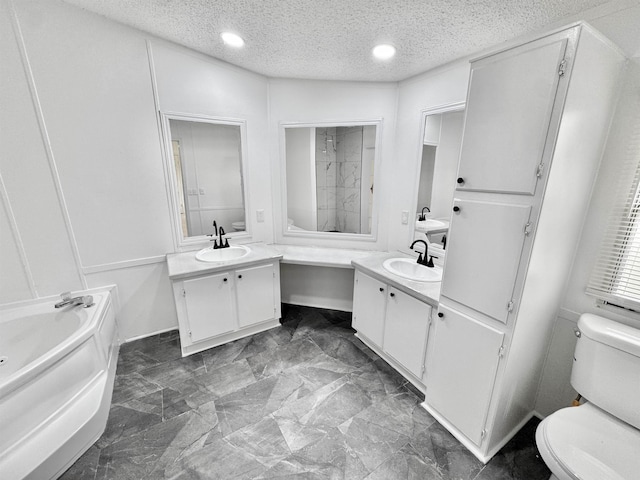 841 Simmons Rd, Munford, TN 38023 - full bathroom with toilet, a bath, two vanities, a textured ceiling, and recessed lighting