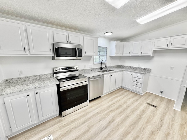841 Simmons Rd, Munford, TN 38023 - kitchen featuring appliances with stainless steel finishes, a sink, a textured ceiling, light wood finished floors, and white cabinets