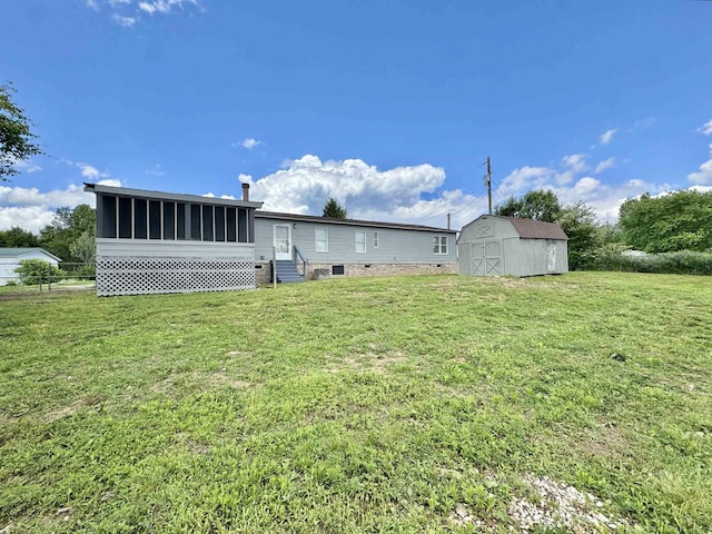 841 Simmons Rd, Munford, TN 38023 - back of property with entry steps, a sunroom, a storage shed, an outdoor structure, and a yard