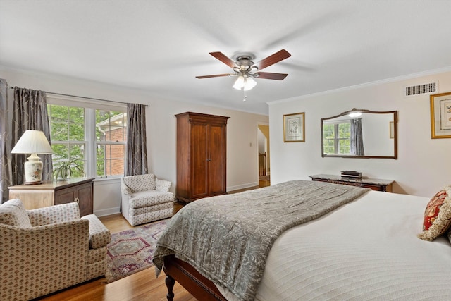 bedroom featuring light wood-type flooring, crown molding, ceiling fan, and baseboards