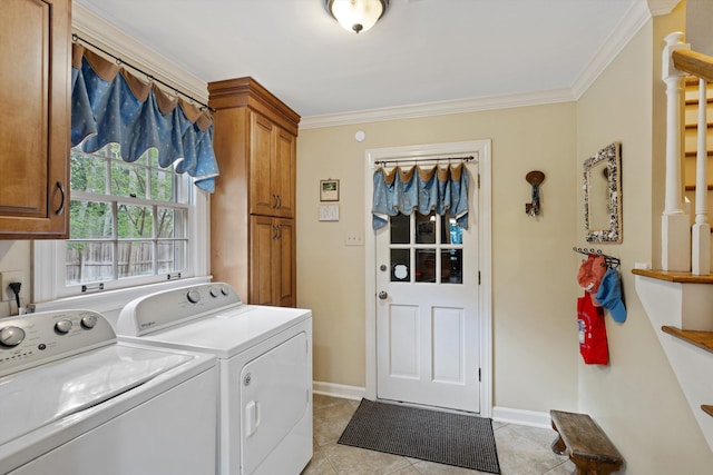clothes washing area with cabinet space, washing machine and clothes dryer, light tile patterned floors, crown molding, and baseboards