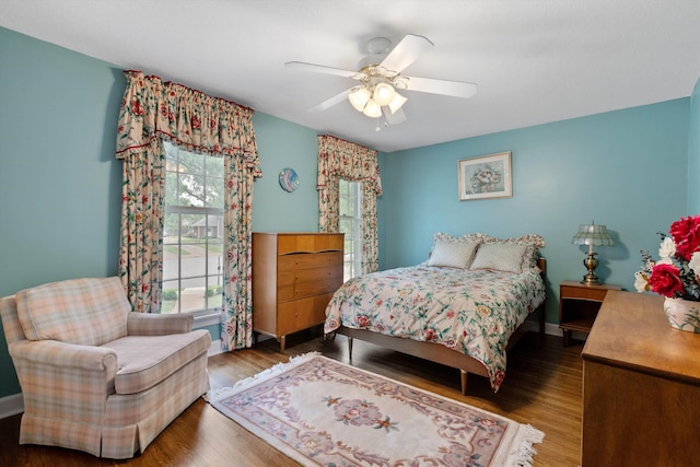 bedroom featuring wood finished floors, a ceiling fan, and baseboards