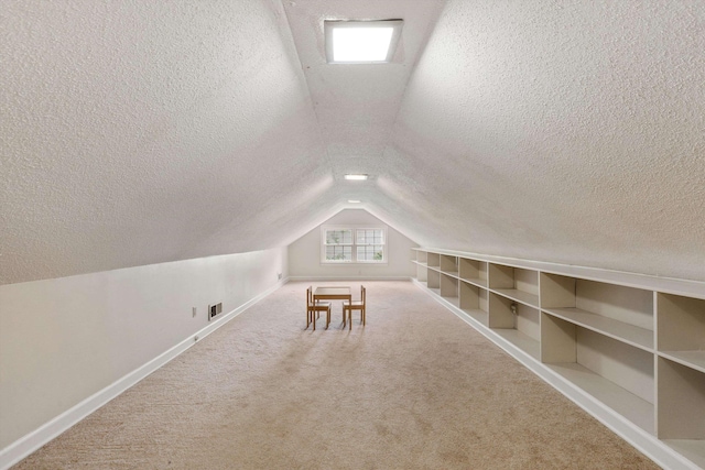 additional living space featuring lofted ceiling, a textured ceiling, baseboards, and carpet flooring