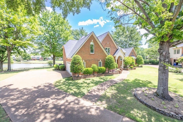 10336 Hatcher Patch Cv, Collierville, TN 38017 - view of front of property featuring concrete driveway, a water view, a front lawn, brick siding, and an attached garage