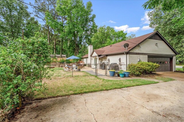 1366 Kirby Rd, Memphis, TN 38120 - view of property exterior with brick siding, concrete driveway, a shingled roof, a garage, and a chimney