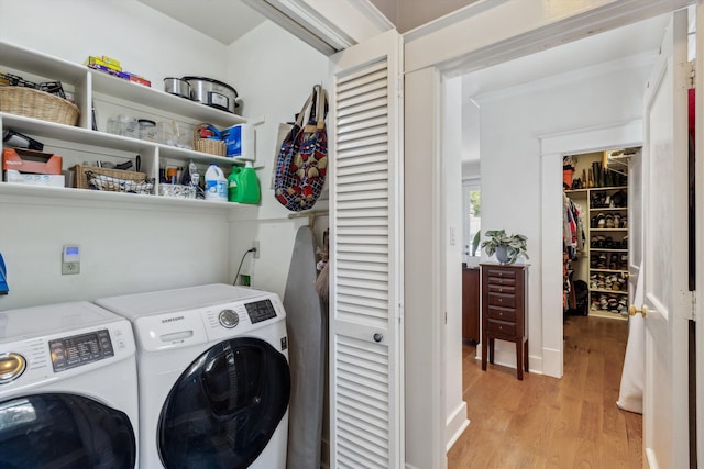 washroom with washing machine and dryer and light wood-style flooring