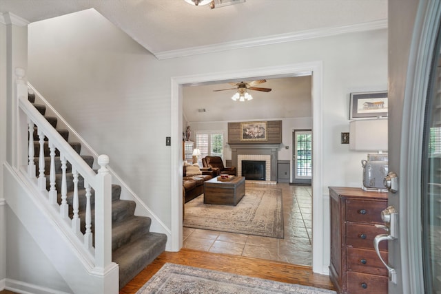 8792 E Carrollwood Ln E, Memphis, TN 38016 - entrance foyer featuring plenty of natural light, ceiling fan, crown molding, a brick fireplace, and stairs