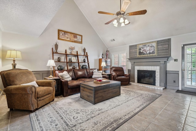 8792 E Carrollwood Ln E, Memphis, TN 38016 - living area featuring ceiling fan, a brick fireplace, crown molding, vaulted ceiling, and a wainscoted wall